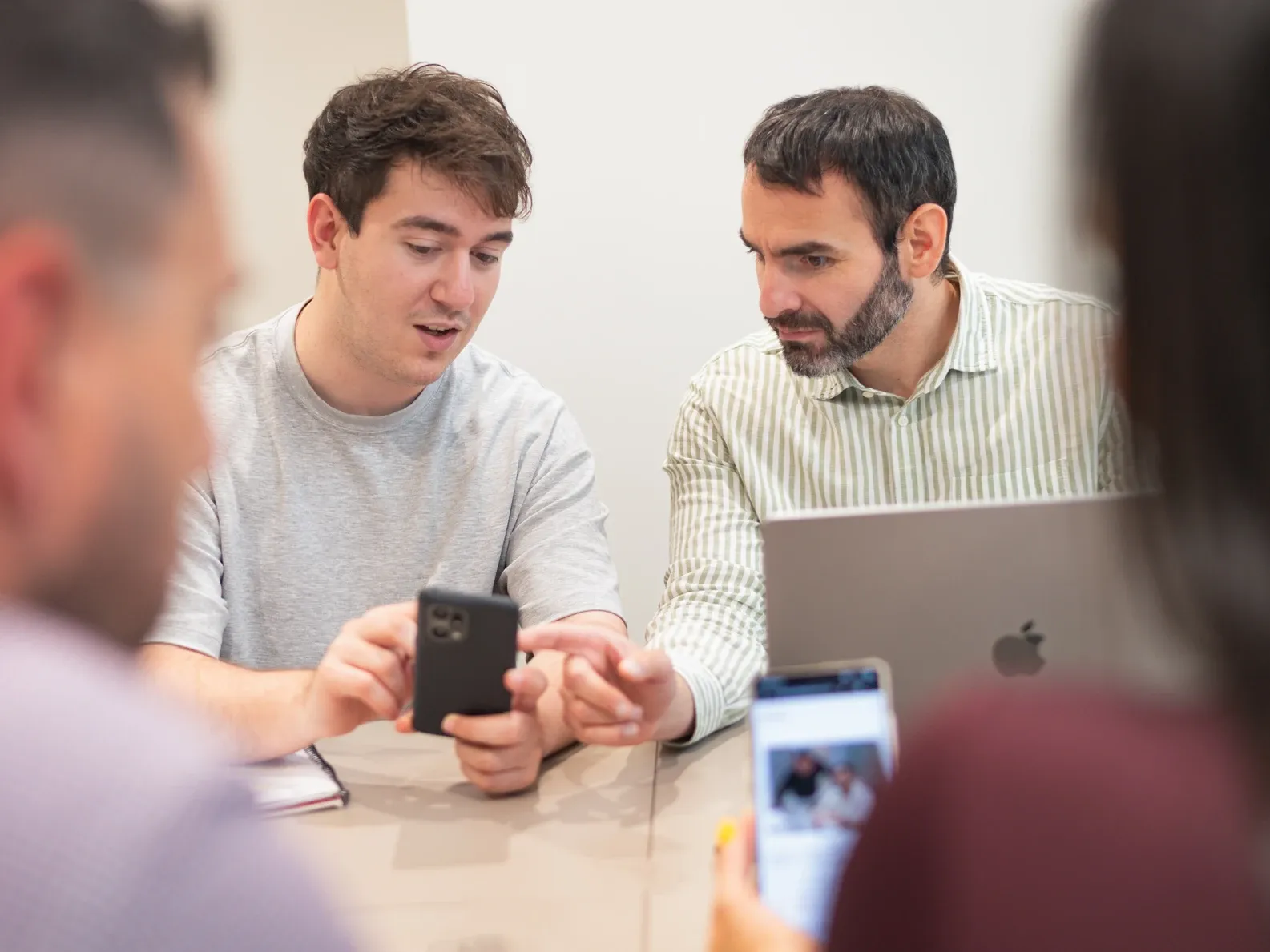 Dos compañeros revisando contenido en el móvil